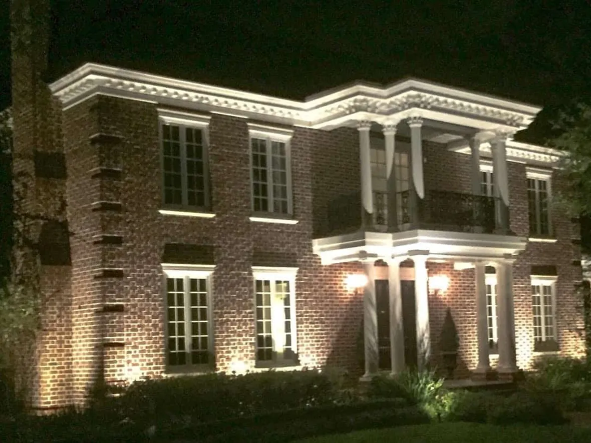 Established planting and architecture lit by a system that has been adjusted as the landscape grew