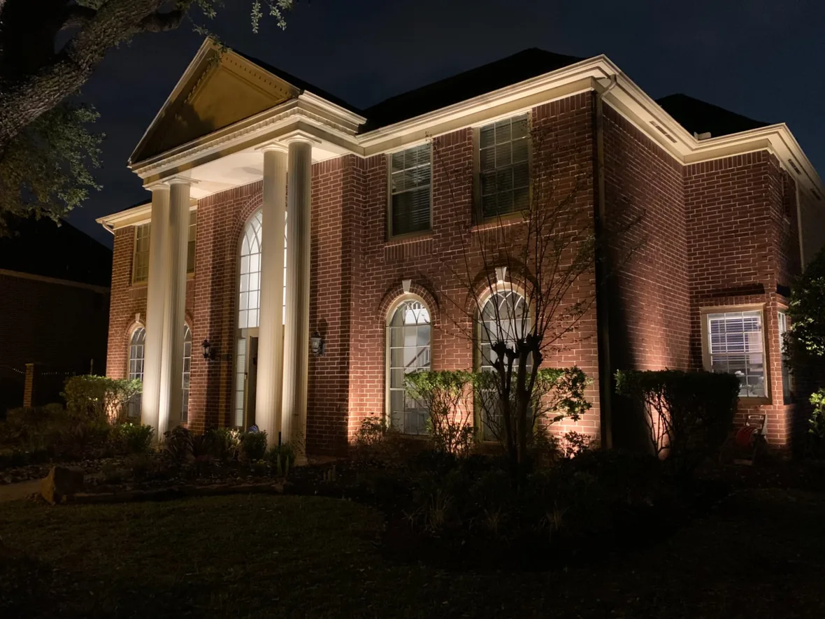 Brick and columns grazed with light so the texture of the masonry is visible