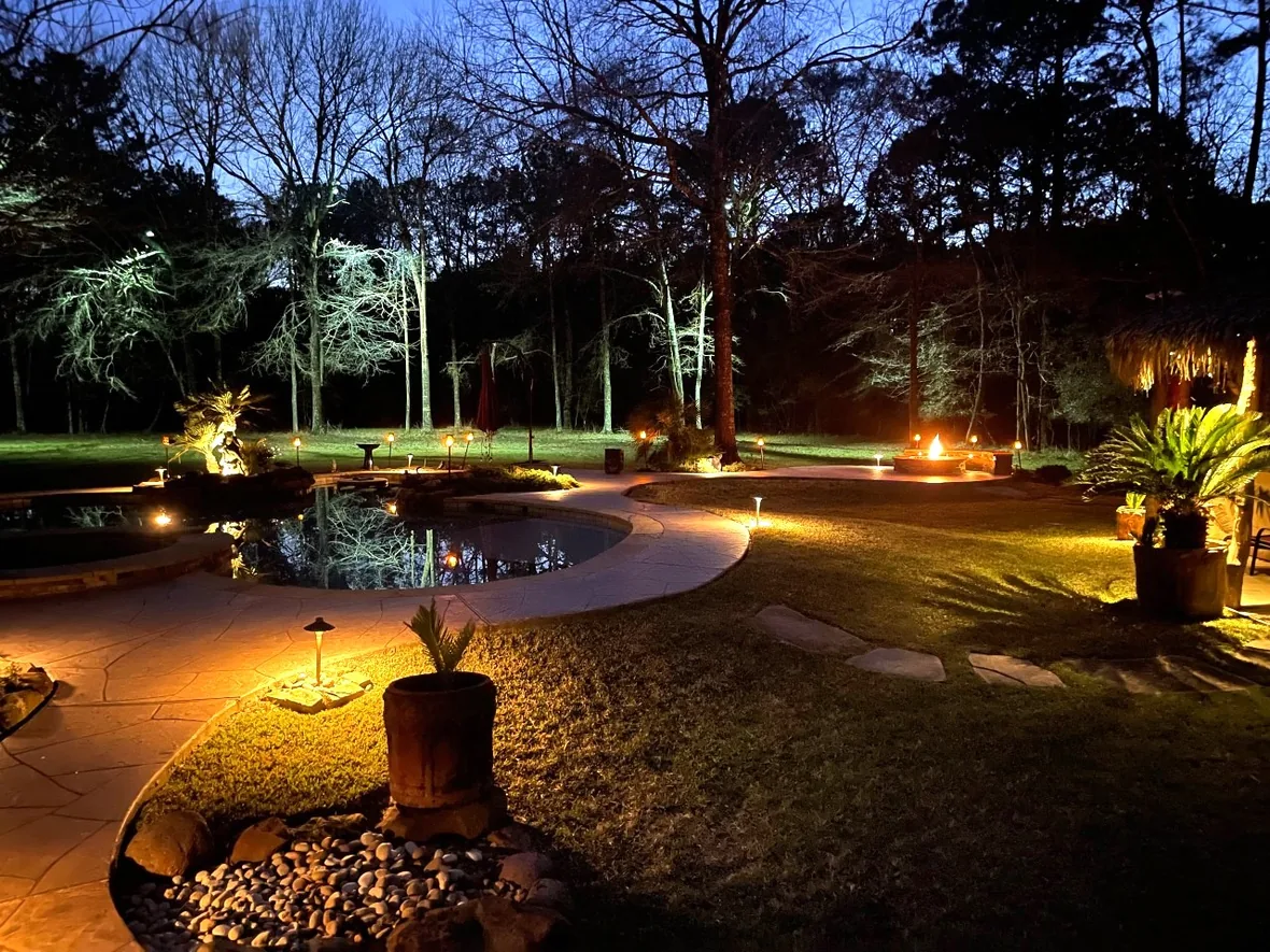 Walkway and planting beds lit by fixtures set back into the landscape so the hardware stays out of view
