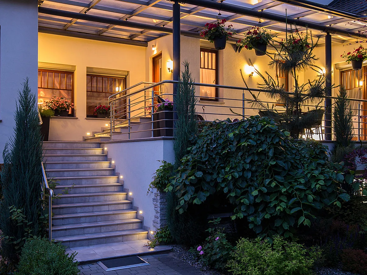 Steps and a low garden wall lit by small fixtures tucked into the structure