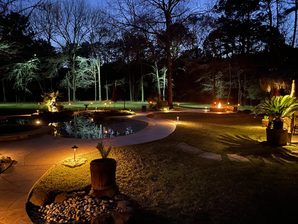 hl-path-backyard-1180.webp Stone walkway through planting at night, lit low so the paving reads and the fixtures stay quiet